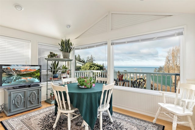 sunroom with a water view and vaulted ceiling