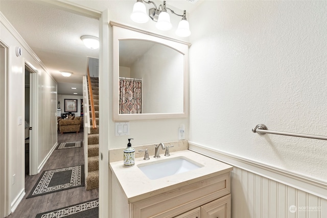 bathroom featuring hardwood / wood-style floors, vanity, and a textured ceiling