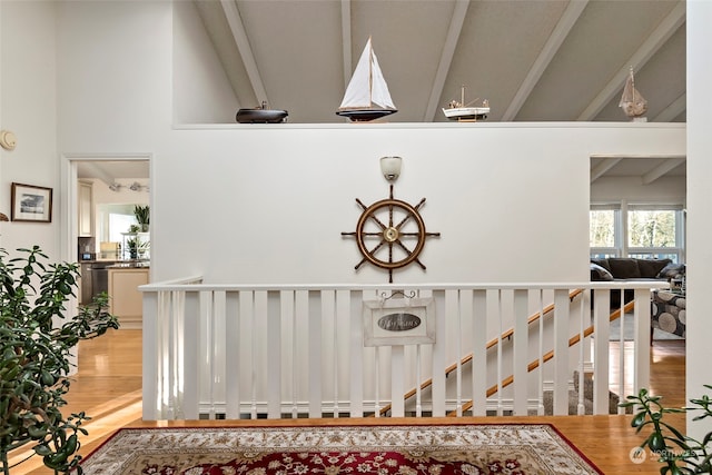 stairway featuring high vaulted ceiling and wood-type flooring