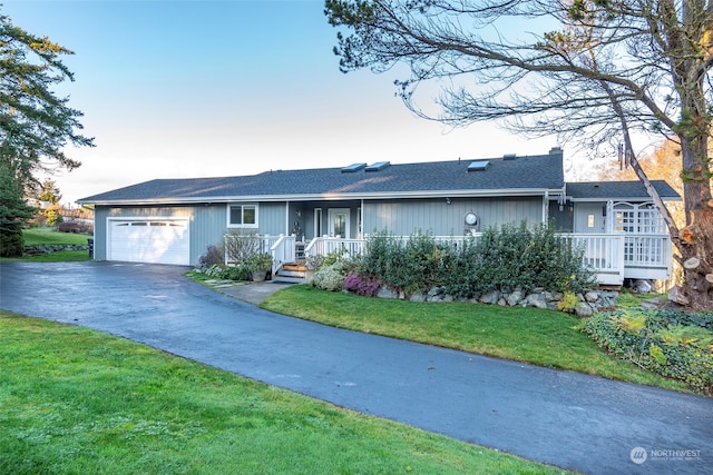 ranch-style home featuring a garage and a yard