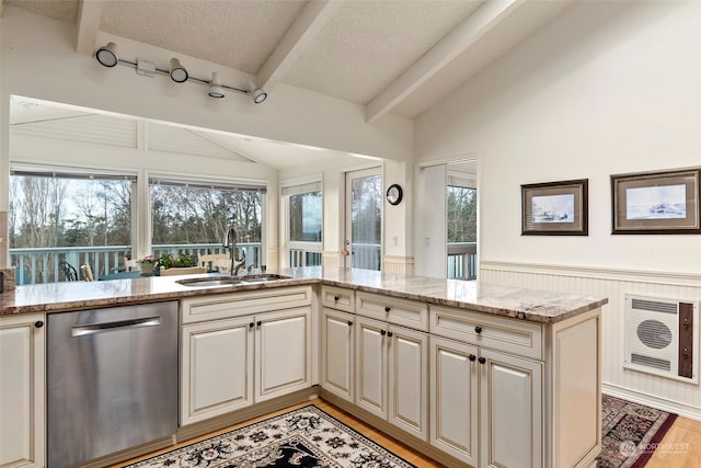 kitchen featuring dishwasher, sink, light stone counters, heating unit, and light wood-type flooring