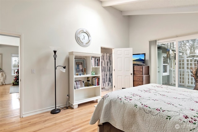 bedroom with lofted ceiling with beams, access to exterior, and wood-type flooring