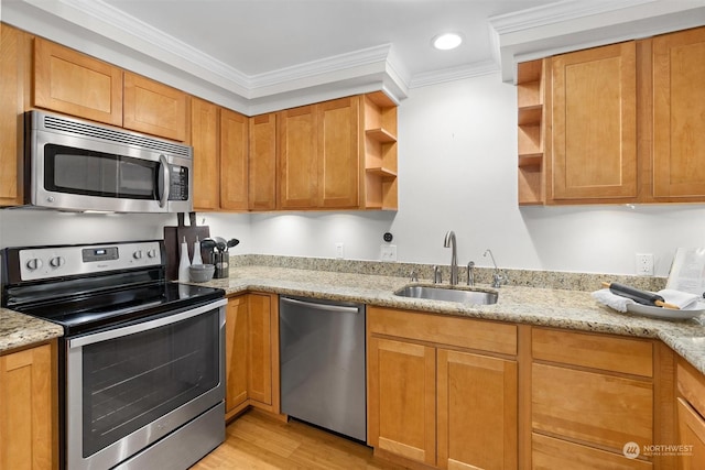 kitchen with light stone countertops, sink, stainless steel appliances, ornamental molding, and light wood-type flooring