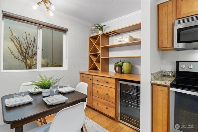 interior space featuring light stone countertops, ornamental molding, light hardwood / wood-style floors, stainless steel appliances, and beverage cooler