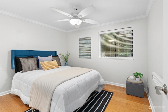 bedroom featuring ceiling fan, wood-type flooring, and ornamental molding