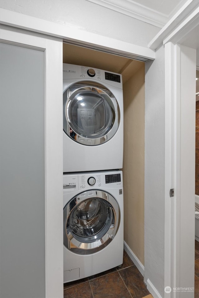 washroom featuring crown molding and stacked washer and clothes dryer