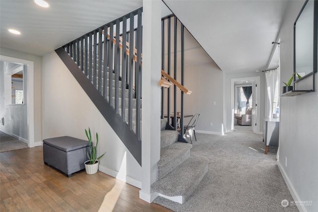 staircase with wood-type flooring and a healthy amount of sunlight