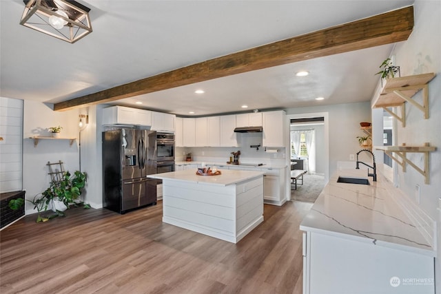 kitchen featuring beamed ceiling, appliances with stainless steel finishes, sink, and white cabinets