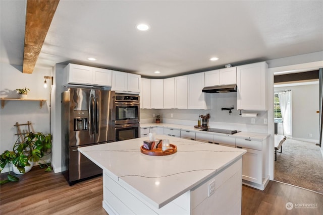 kitchen with white cabinetry, stainless steel appliances, hardwood / wood-style floors, and a kitchen island