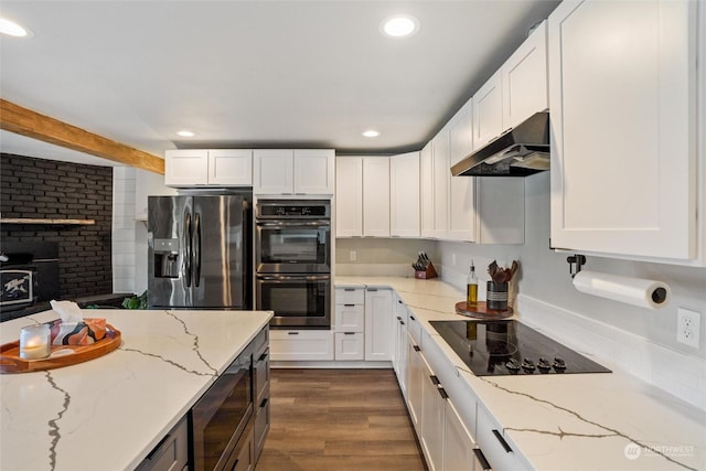 kitchen with dark wood-type flooring, appliances with stainless steel finishes, light stone counters, white cabinets, and beamed ceiling