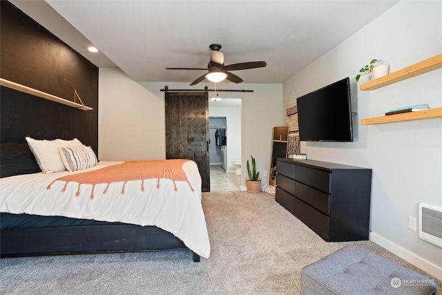 bedroom with light carpet, heating unit, a barn door, and ceiling fan