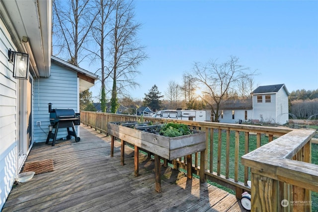 wooden terrace with a grill and a lawn