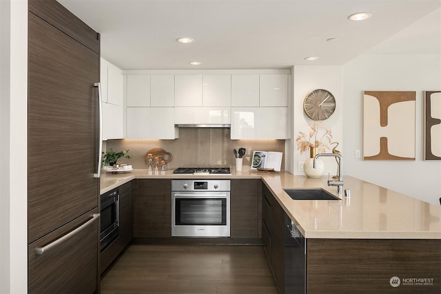 kitchen featuring black appliances, dark brown cabinetry, white cabinetry, and sink