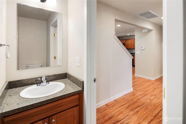 bathroom featuring vanity, hardwood / wood-style flooring, and toilet