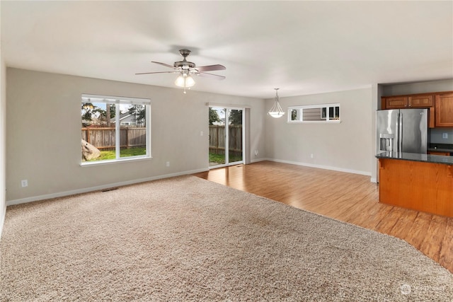 unfurnished living room featuring light wood-type flooring and ceiling fan