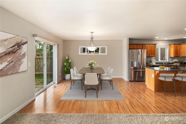 dining area with sink and light hardwood / wood-style flooring