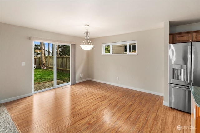 unfurnished dining area featuring light wood-type flooring