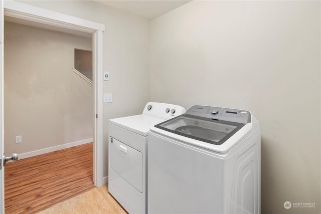 washroom featuring light hardwood / wood-style floors and washing machine and clothes dryer