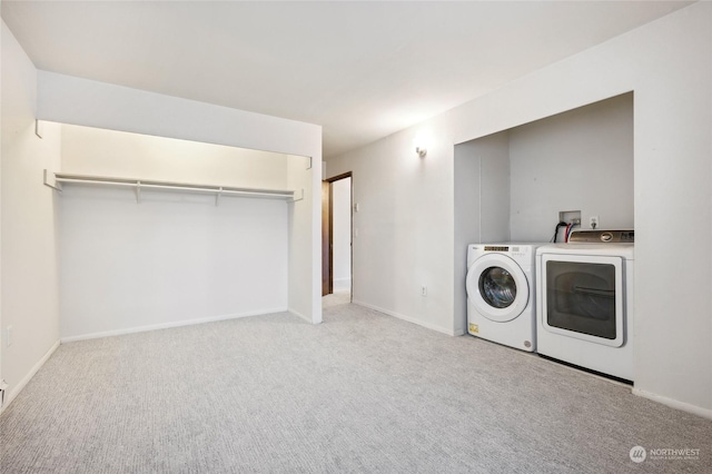 clothes washing area with light carpet and washing machine and clothes dryer