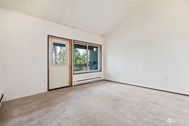 spare room with a baseboard radiator, light colored carpet, and vaulted ceiling