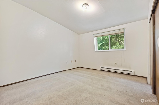 spare room with light colored carpet, a baseboard radiator, and vaulted ceiling