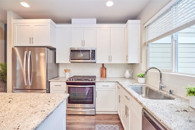 kitchen featuring white cabinetry, sink, appliances with stainless steel finishes, and tasteful backsplash