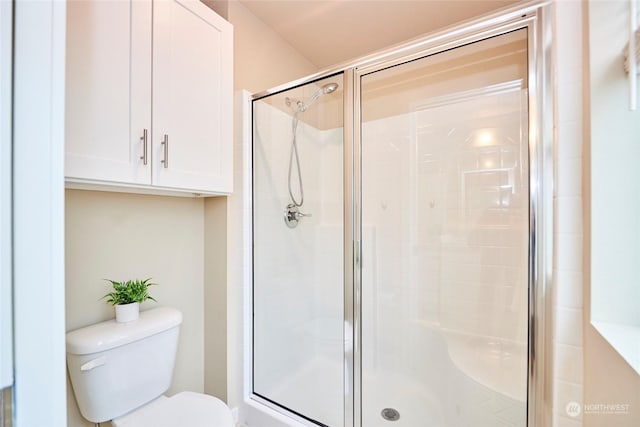 bathroom featuring toilet and an enclosed shower