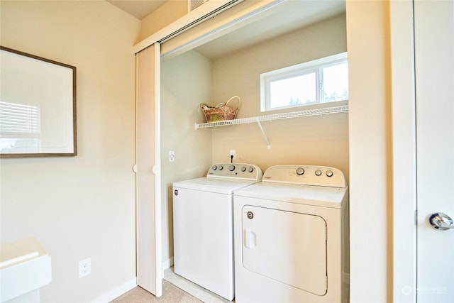 laundry area featuring washing machine and dryer and light carpet