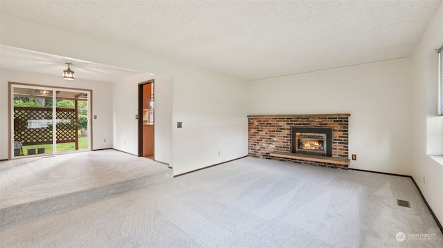 unfurnished living room with a brick fireplace, a textured ceiling, and light carpet