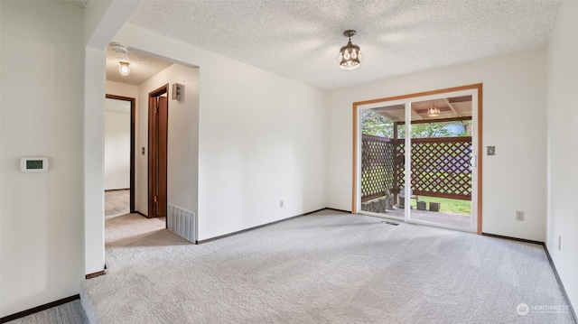 carpeted spare room with a textured ceiling