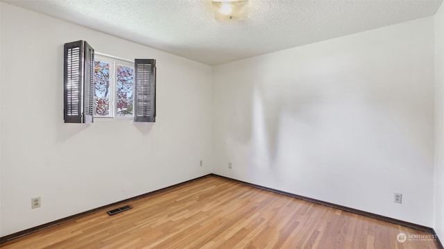 spare room with wood-type flooring and a textured ceiling