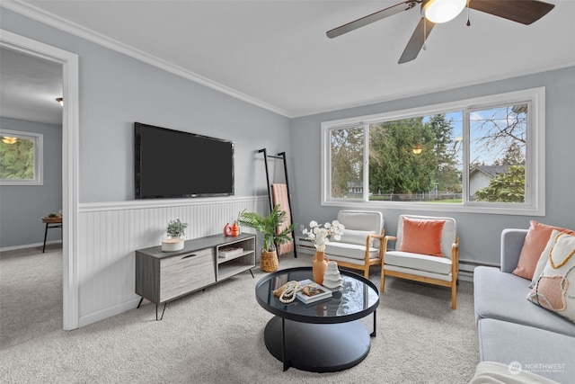 carpeted living room featuring crown molding, plenty of natural light, and ceiling fan