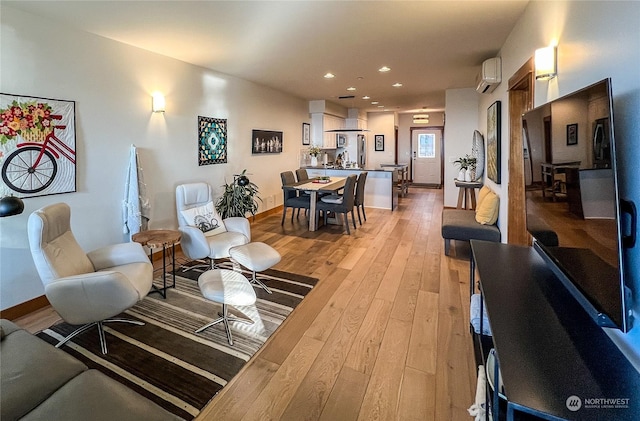 living room featuring light wood-type flooring and a wall unit AC