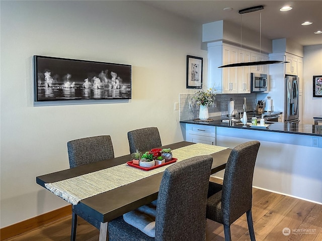 dining room with sink and wood-type flooring