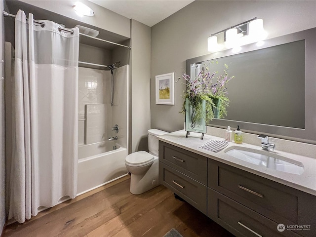 full bathroom with toilet, hardwood / wood-style flooring, vanity, and shower / bath combo with shower curtain