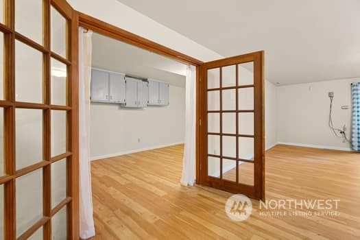 additional living space featuring lofted ceiling and light hardwood / wood-style flooring