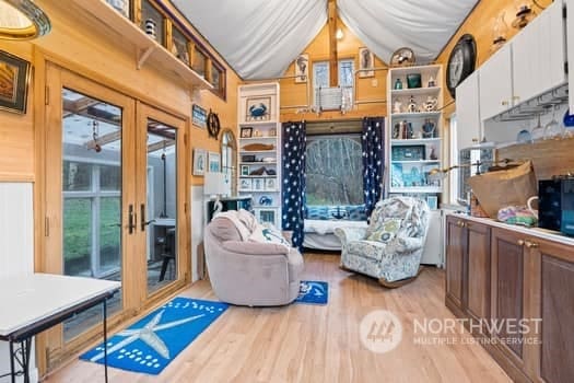 interior space with french doors, wood walls, and light hardwood / wood-style flooring