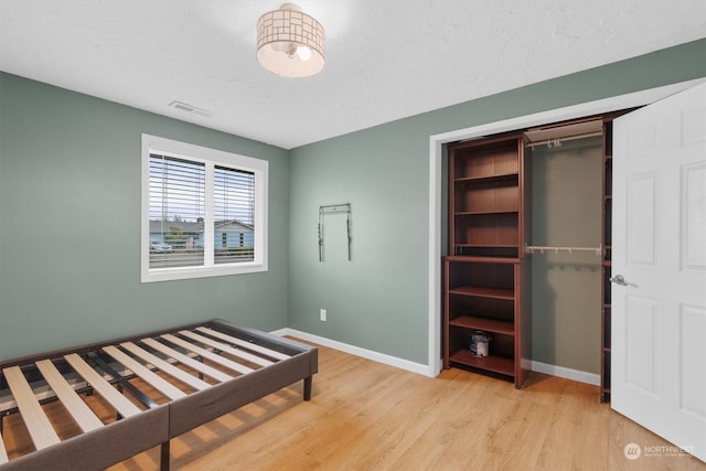 unfurnished bedroom with light hardwood / wood-style floors and a closet