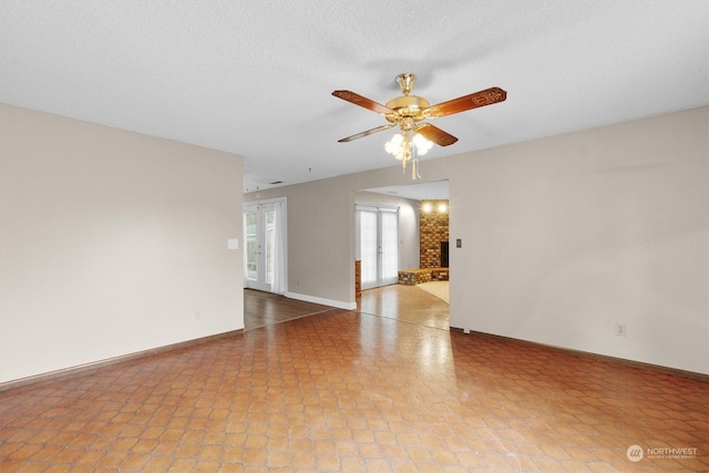 unfurnished room featuring ceiling fan, a textured ceiling, and french doors