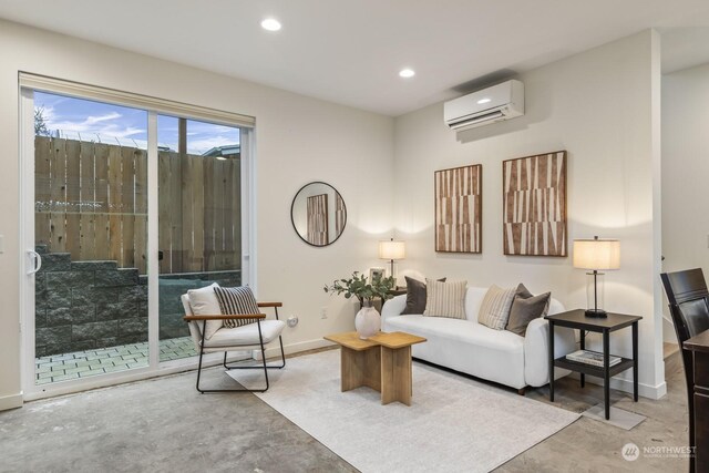 living area with a wall mounted air conditioner, recessed lighting, baseboards, and concrete floors