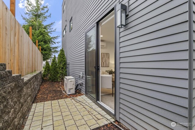 view of patio with ac unit, a wall mounted air conditioner, and fence