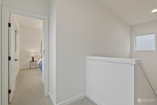 corridor featuring recessed lighting, baseboards, an upstairs landing, and light colored carpet