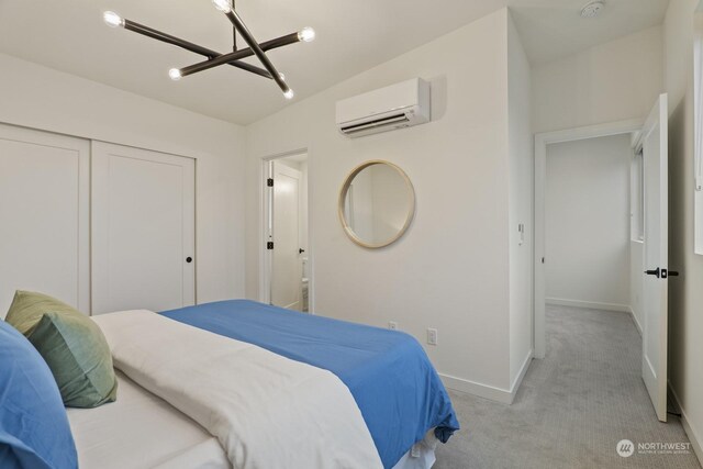 bedroom featuring light carpet, a closet, an AC wall unit, and baseboards