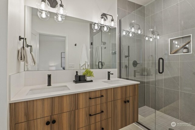 full bath featuring double vanity, a shower stall, and a sink