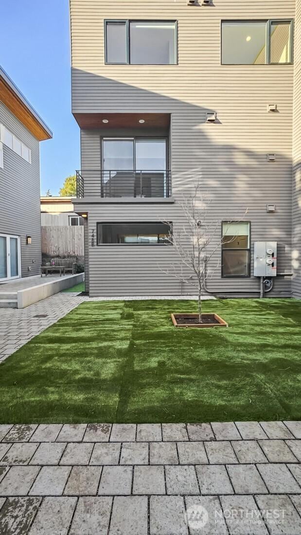 rear view of property with a yard and a patio area