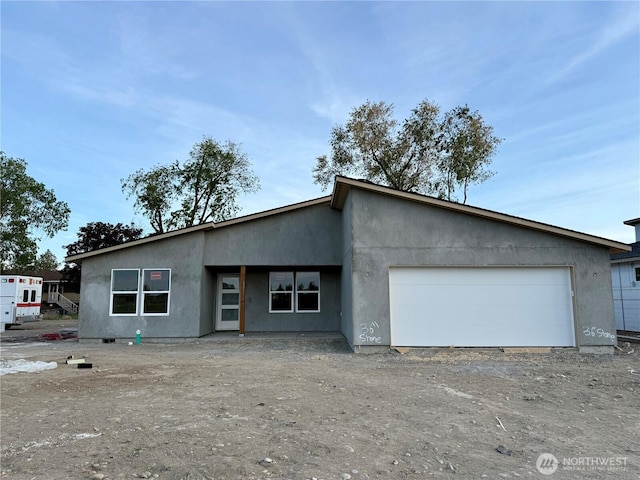 518 S Dorsing St, Moses Lake, WA 98837 - view of front of house with dirt driveway, a garage, and stucco siding
