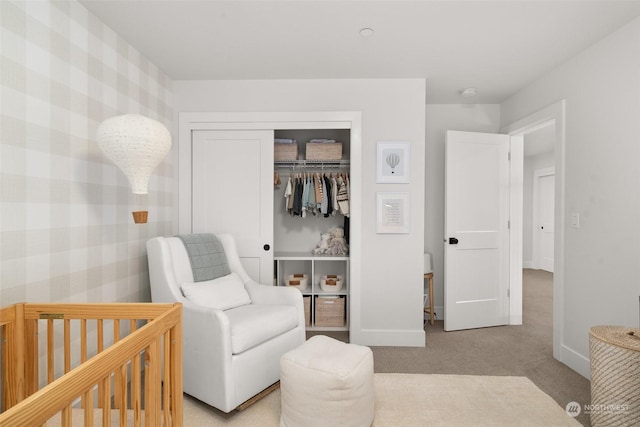 bedroom with light colored carpet, a crib, and a closet