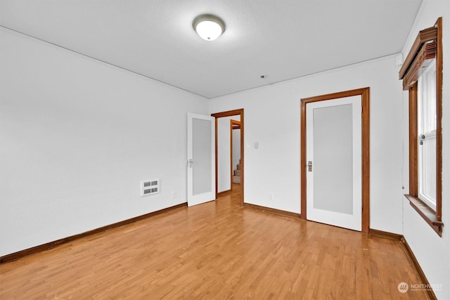 unfurnished bedroom with light wood-type flooring and a textured ceiling