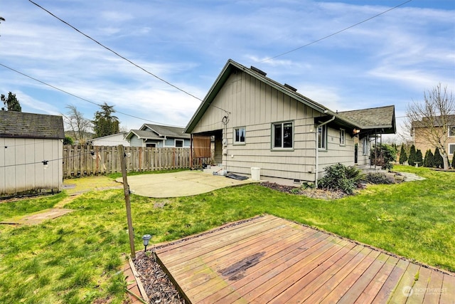 back of house featuring a yard, a patio, and a wooden deck