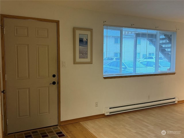 entryway featuring light wood-type flooring, a baseboard radiator, and plenty of natural light